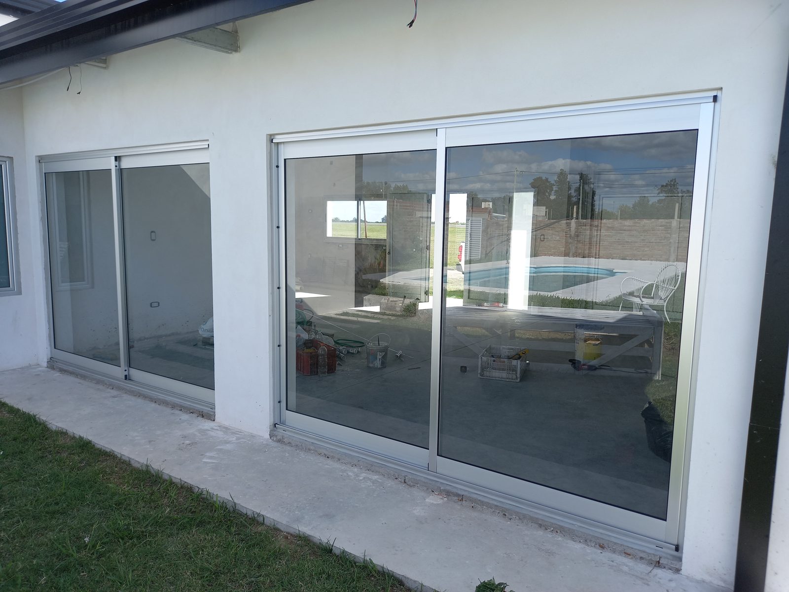 Ventanales corredizos de aluminio con vista a la pileta